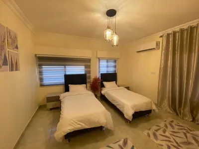 a bedroom with two beds and a window at Lovely 3-bedrooms rental unit in Aqaba