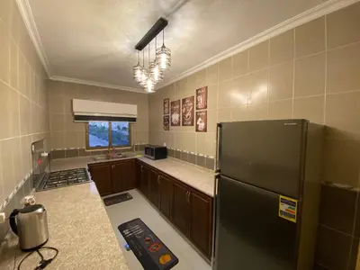 a kitchen with a black refrigerator in a room at Lovely 3-bedrooms rental unit in Aqaba