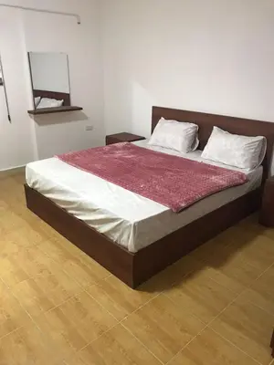 a large bed in a bedroom with a wooden floor at Elite Furnished Apartment in Wadi Musa