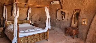 a bedroom with a canopy bed and a table at Obeid's Bedouin Life Camp in Wadi Rum