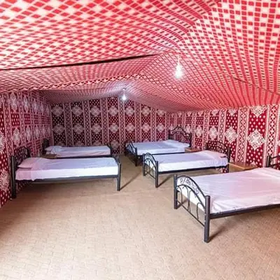 a room with three beds and a red ceiling at Obeid's Bedouin Life Camp in Wadi Rum