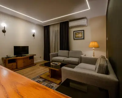 a living room with a couch and a tv at Prestige Hotel Suites - برستيج للشقق الفندقية in Amman