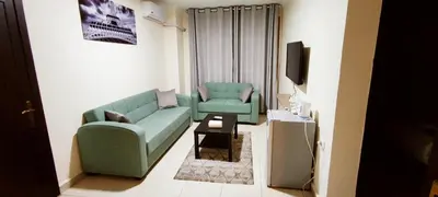 a living room with a green couch and a tv at Golden Hotel in Amman