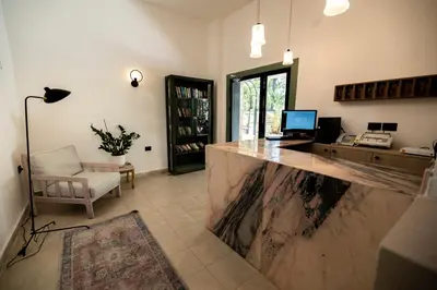 a lobby with a counter with a computer and a chair at Julia's Hotel Suites in Amman