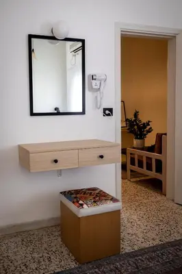 a mirror on a wall above a dresser with a box at Julia's Hotel Suites in Amman