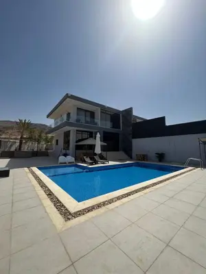 a swimming pool in front of a house at Follow Sea Villa in Sowayma
