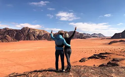 two people standing on a rock in the desert at Mohammed Mutlak Camp in Wadi Rum