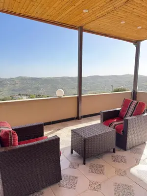 a balcony with two chairs and a table and windows at Abu Hossam s chalet in Jerash