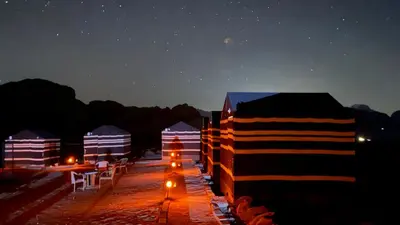 a row of tents at night with lights on them at Wadi Rum Desert Heart Camp in Wadi Rum