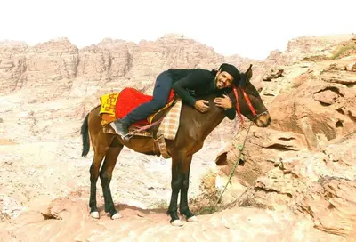 a man riding on a horse in the desert at Issa Snaffi Bedouin home in Wadi Musa