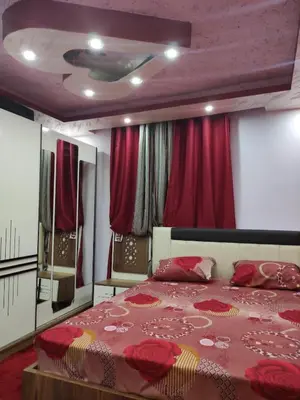 a bedroom with a large bed with red curtains at Issa Snaffi Bedouin home in Wadi Musa
