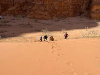 a group of people walking in the desert at The sunset of Wadi Rum in Wadi Rum