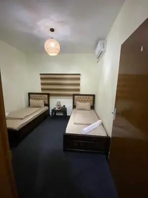 a room with two beds and a table in it at Hustle's look in Wadi Musa