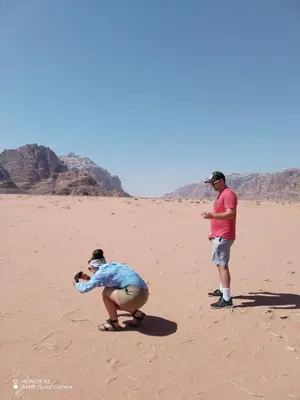 two men are standing in the sand in the desert at Rum desert camp in Wadi Rum