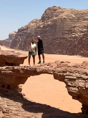 two people standing on a bridge in the desert at Bedouin Desert Cave in Wadi Rum