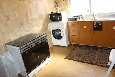 a kitchen with a stove and a washing machine at Alice & Andrew Apt. Few Steps to Madaba Old City Center in Madaba