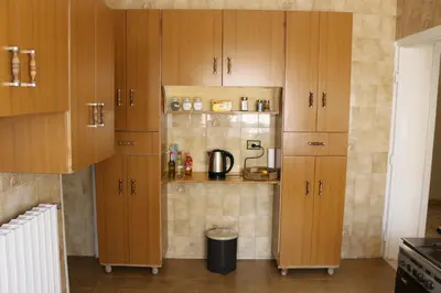 a kitchen with wooden cabinets and a coffee maker at Alice & Andrew Apt. Few Steps to Madaba Old City Center in Madaba