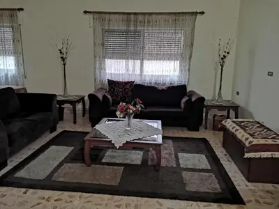 a living room with couches and a coffee table at Alice & Andrew Apt. Few Steps to Madaba Old City Center in Madaba