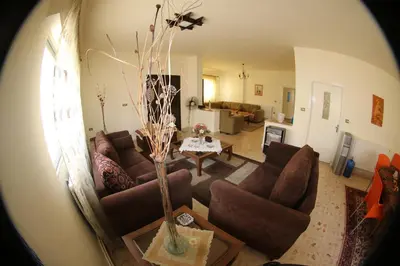 a living room with brown couches and a table at Alice & Andrew Apt. Few Steps to Madaba Old City Center in Madaba