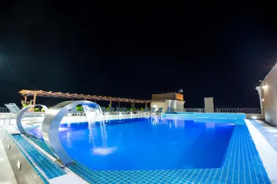 a large swimming pool with a water fountain at Petra Moon Luxury Hotel in Wadi Musa