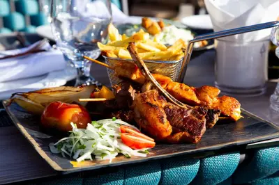 a plate of food with meat and french fries at Petra Moon Luxury Hotel in Wadi Musa
