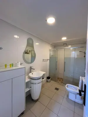 a bathroom with a sink and a toilet and a shower at 7 Days Hotel in Umm Uthainah