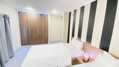 a hotel room with two beds and a window at 7 Days Hotel in Umm Uthainah