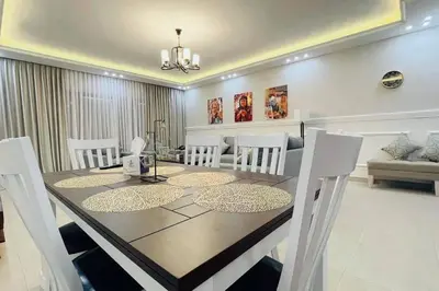 a dining room with a table and white chairs at Maria Beach Ground Floor Apartament in Aqaba