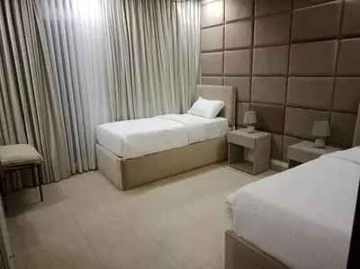 a hotel room with two beds and two tables at Maria Beach Ground Floor Apartament in Aqaba