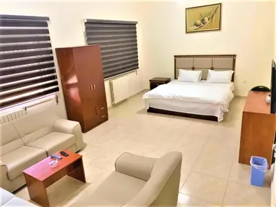 a hotel room with a bed and a couch at Nojoom Hotel in Amman