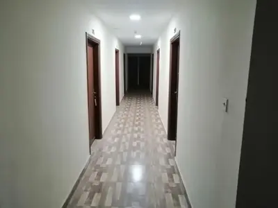 a hallway with white walls and a tile floor at Nojoom Hotel in Amman