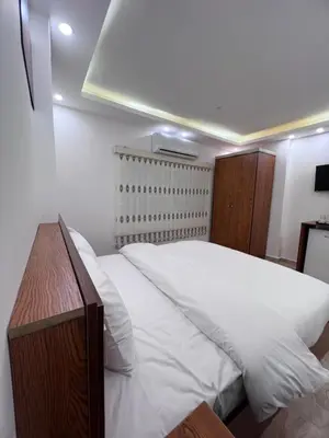 a bedroom with a large bed with white sheets at Petra Family Hotel in Wadi Musa