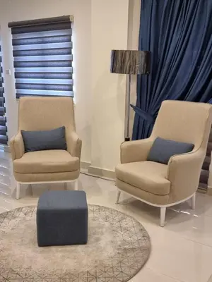two chairs and a ottoman in a living room at Byblos Prime in Aqaba