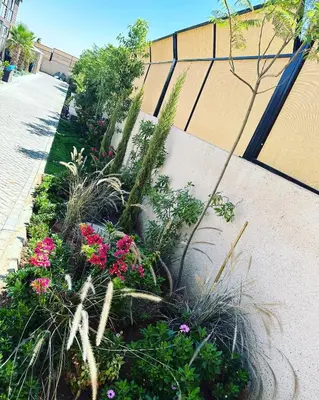 a garden with flowers and plants on a sidewalk at The royal cottage Amman in Al Qasţal