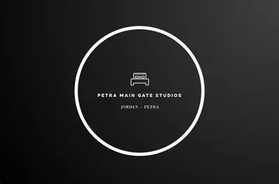 a white circle on a black background with a picture of a camera at Petra Main Gate Studios in Wadi Musa