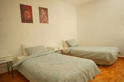 a room with two beds and a chair in it at Petra Main Gate Studios in Wadi Musa