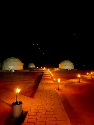 a row of lights on a brick road at night at Nara Wadi RUM Camp in Wadi Rum