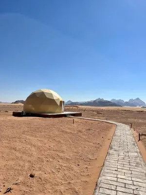 a tent in the middle of a desert with a road at Nara Wadi RUM Camp in Wadi Rum