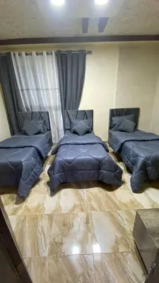 a room with three beds in a room at Petra Rose Apartment in Wadi Musa
