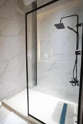 a shower with a glass door in a bathroom at مزرعة وفيلا الريان وادي رم in Ruʼaysat al Khālidī