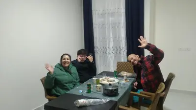 three people sitting at a table with their hands in the air at Petra Inn House in Wadi Musa