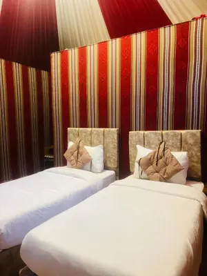 two beds sitting next to each other in a room at Anwar Al Qamar Luxury Hotel in Wadi Rum