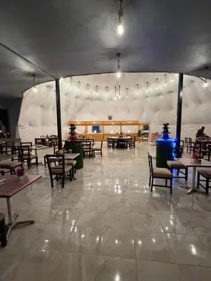 a dining area with tables and chairs in a tent at Anwar Al Qamar Luxury Hotel in Wadi Rum