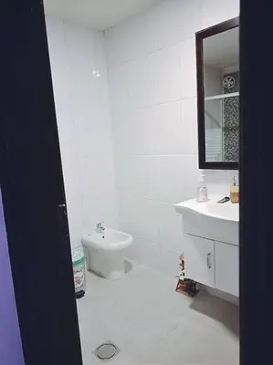 a white bathroom with a sink and a toilet at Pomegranate Tree in Wadi Musa