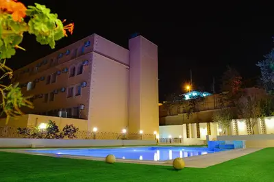 a large building with a swimming pool at night at Petra Castle Hotel in Wadi Musa