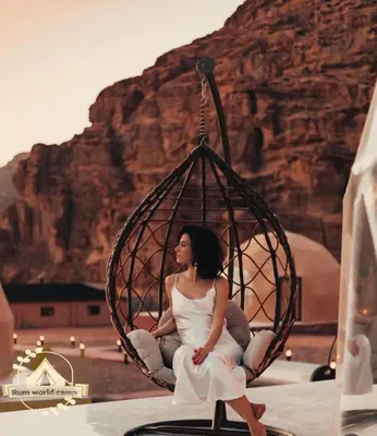 a woman sitting in a swing in the desert at RUM WORLD BUBBLE lUXURY CAMP in Wadi Rum