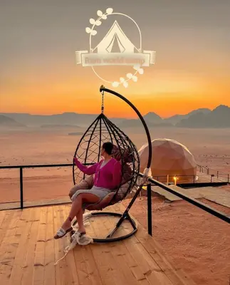 a woman sitting in a swing in the desert at RUM WORLD BUBBLE lUXURY CAMP in Wadi Rum