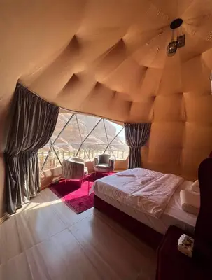 a bedroom with a bed and a large window at Wadi rum desert sky in Wadi Rum