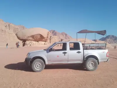 a white pick up truck parked in the desert at Wadi rum desert sky in Wadi Rum