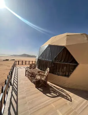 a tent with chairs and a table on the beach at Wadi rum desert sky in Wadi Rum
